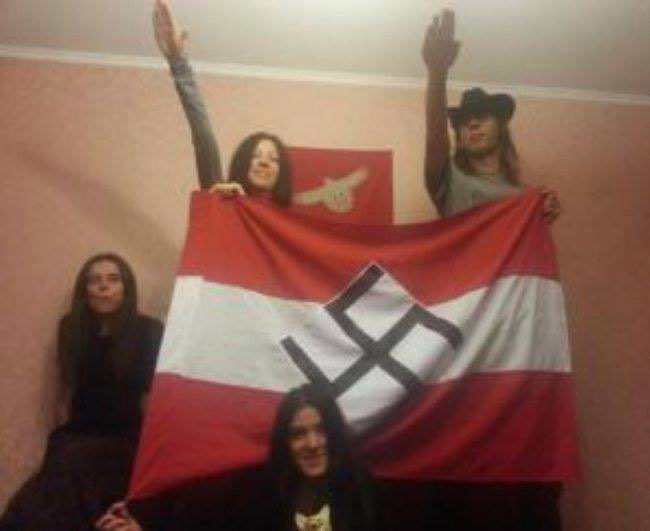 Foto som angivelig viser Olena Semenyaka sammen med andre personer foran et naziflagg, mens hun og en annen gjør nazihilsen.