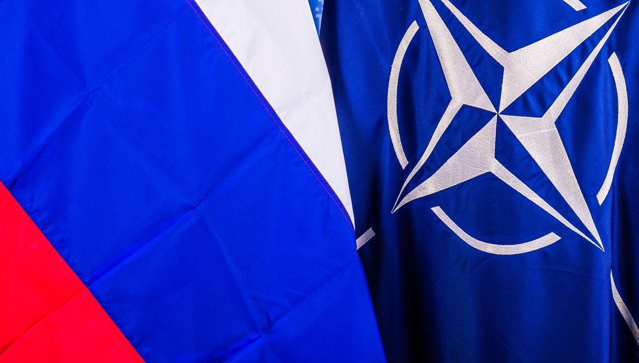 Nærbilde av Russlands flagg ved siden av NATOs flagg.