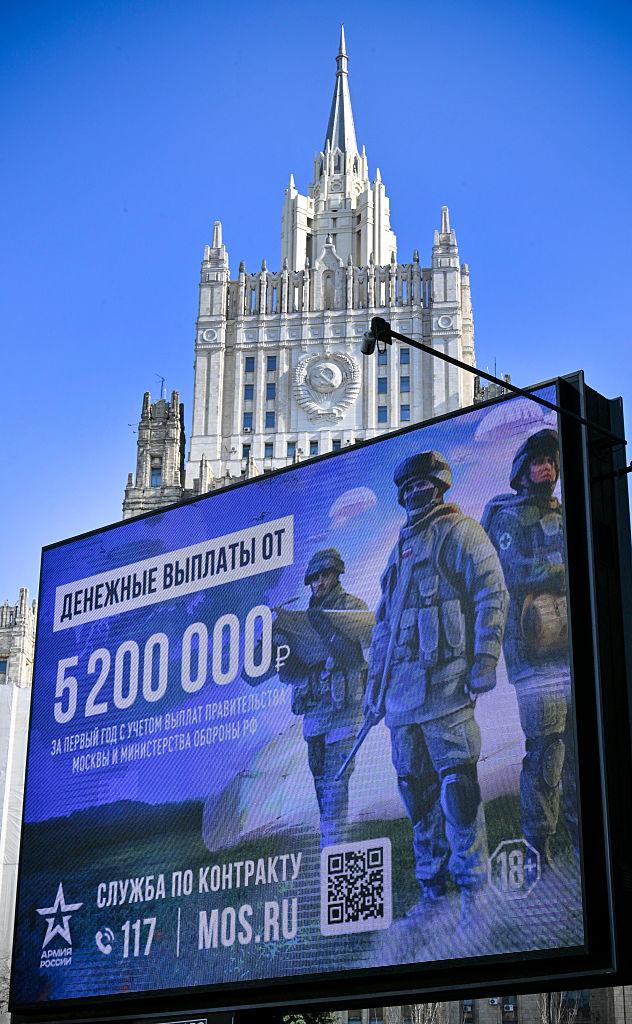 Stor digital reklametavle i Moskva med russiske soldater og tekst om betaling for kontraktstjeneste.